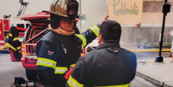Guiding in the community…Following a building fire, firefighter Greg Hughes 
explains to fellow firefighters the process involved in following up once the fire 
is out.