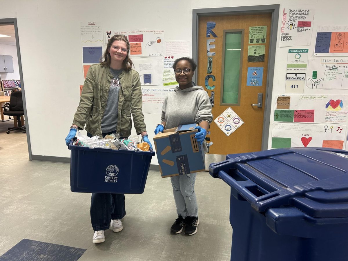 Helping Hands… Makaila Robinson and Kayliegh Sprute collect tubs for the Environmental Club’s recycling project. The Club spent one afternoon each month of the school year collecting bins.