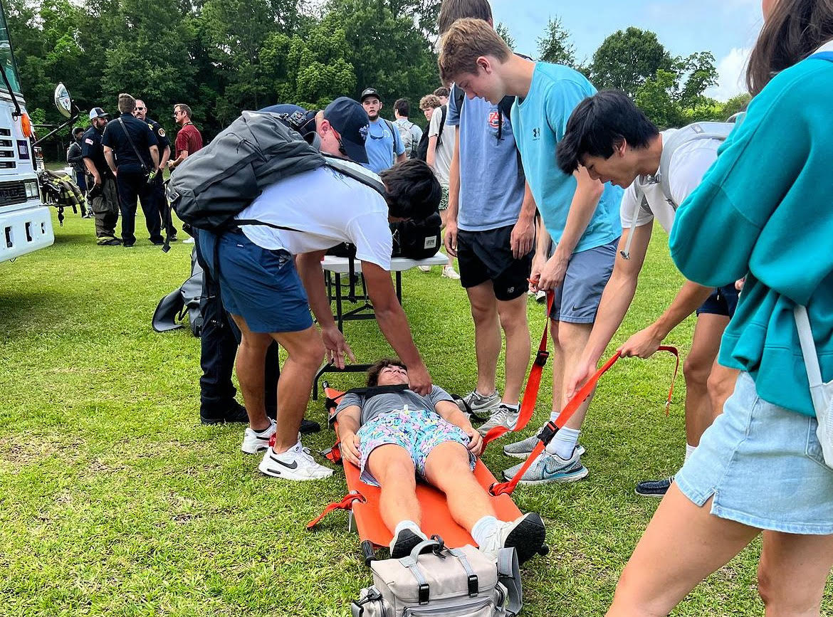 Strapping in…Students practice using a stretcher and carrying a student on it. Students performed a drill to further understand the role of an EMT. Photo courtesy of Fairhope High Instagram.