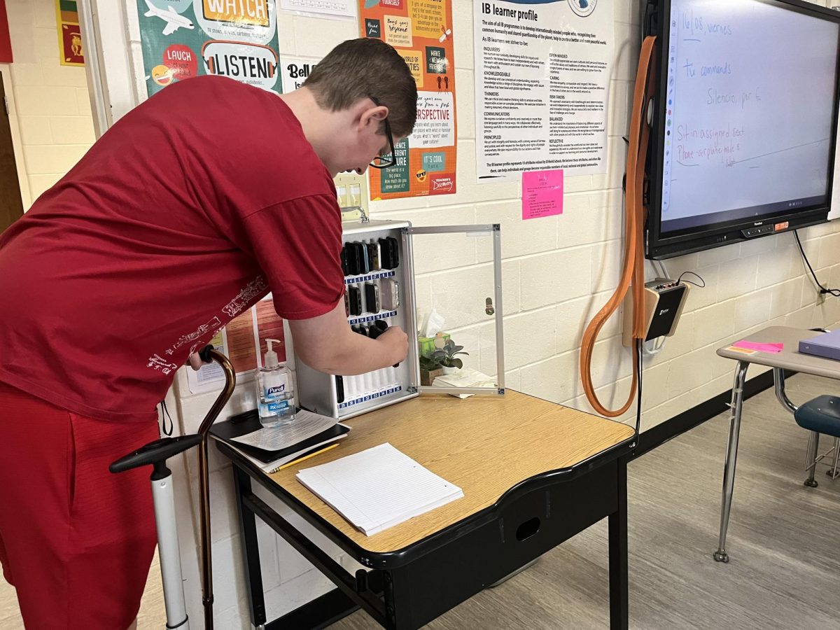 Locking the box… Fairhope High School junior Ethan Sugg places his phone in the lockbox upon arrival to class. He and his classmates silenced their phones, took a seat and prepared for class. 