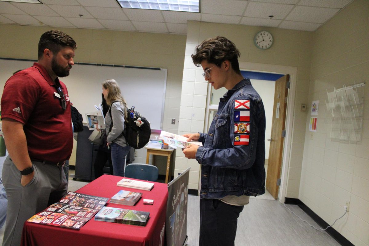 Engaged and curious… Senior Parker Burk listens attentively to a Troy University representative discussing programs and campus life. The representative gave Burk pamphlets and contact cards to help him get the information he needed.