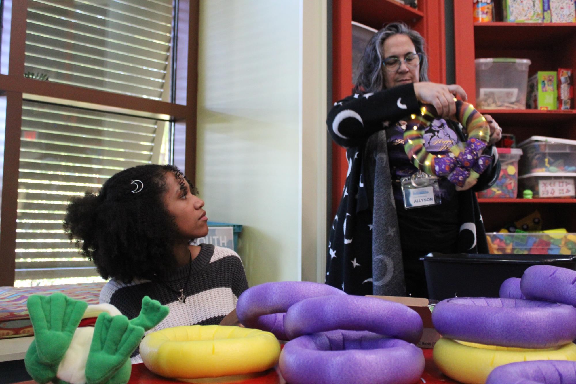 Crafting creations… Allyson Russel demonstrates how to tie fairy lights around the reefs. Hailey Jackson practiced this skill on her own and created her Halloween reef.