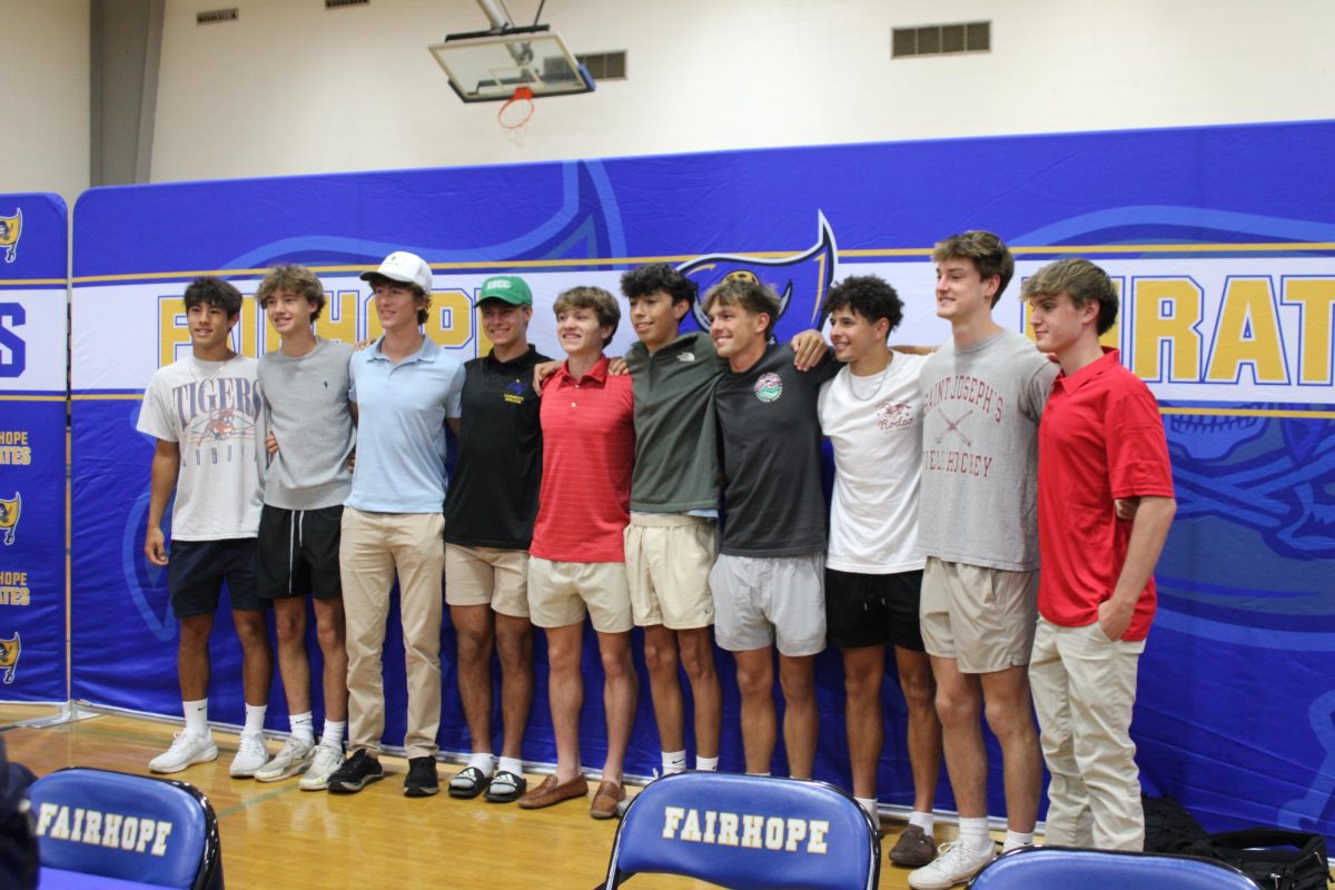 Friendly Support… Friends and teammates of senior Chance Walters congratulate him after the signing ceremony. Fairhope High School Students were invited to come watch their friends and support them during the school day.