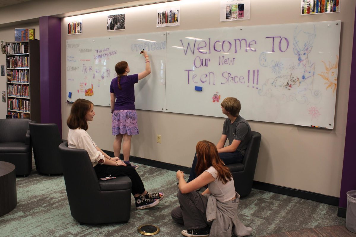 Creative Energy… Fairhope teens Ainsley Cook, Mabel Burch, Samantha Jensen and Cannon Deason hang out and draw on the whiteboard in the new teen space. Library worker Casey Henderson allowed all teens to draw on the board so that they could make the space their own. “We wanted to have it so that teens had ownership over the space,” Henderson said.