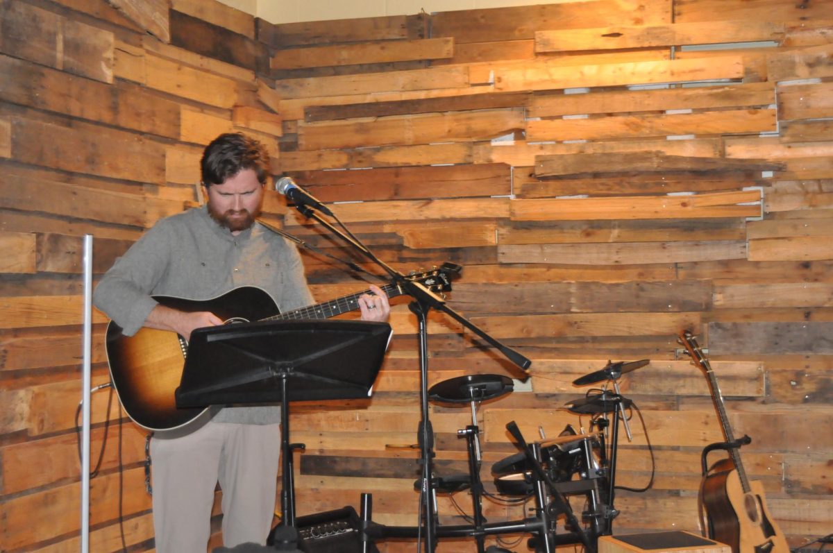 Guitar master…. Worship leader Mitch Johnston practices his guitar. Johnston performed during worship.
