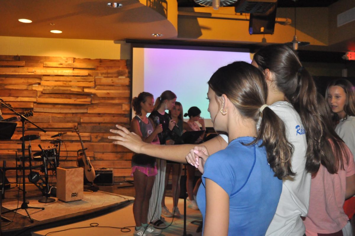 Hands up...Martin and freshman Rebecca Huffman raise their hands in praise. Huffman and Martin continued to raise their hands and voices in praise throughout the worship service.