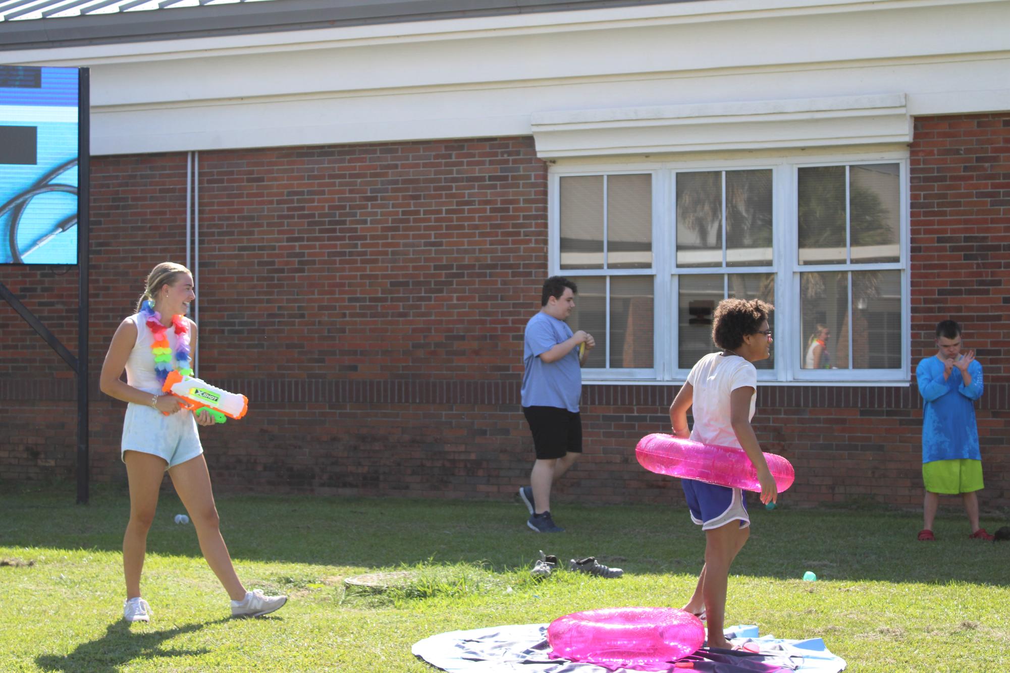 Water activities...Mary Marshall Roberts squirts Jubilee students with a water gun to try and encourage them to try the slip n slide.
