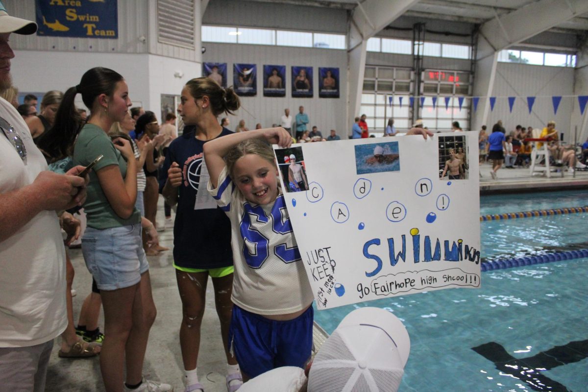 Families support… Tatum Shepard holds a poster to cheer on her brother, Caden Shepard. Shepherds' family cheered for him as he beat his personal record. 