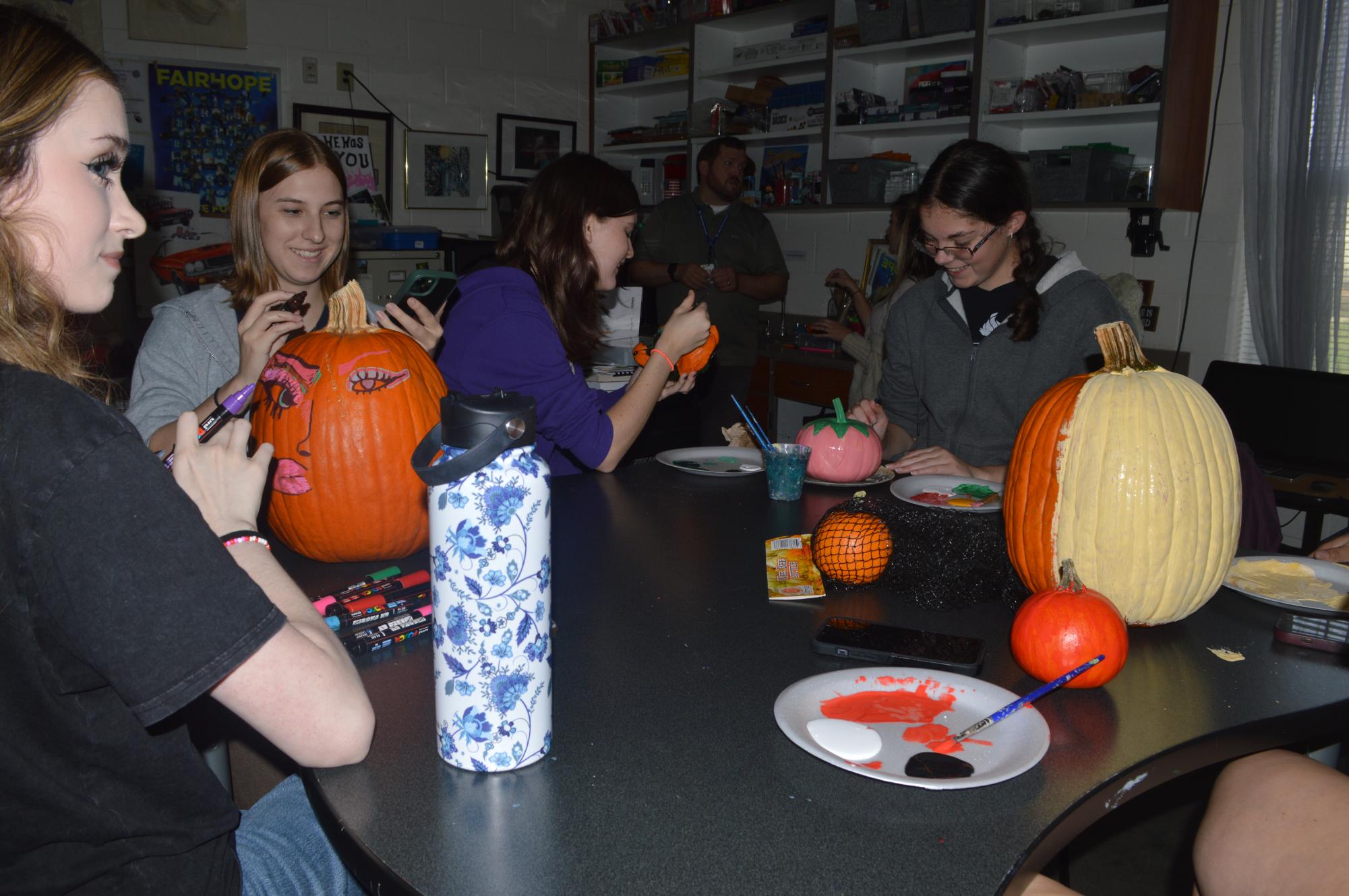 All together now… students from the art and garden club paint pumpkins. When the students finished their pumpkins they entered their paintings into the competition. (Penny Hood)