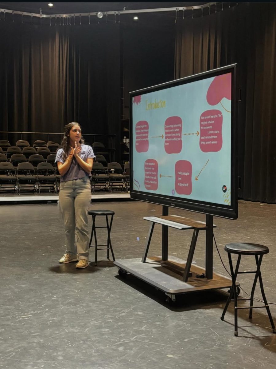 Isabella Casolaro presents the values of a peer helper and the core helping skills. The group practiced these skills through exercises and activities. Photo courtesy of Fairhope Peer Helpers Instagram. 

