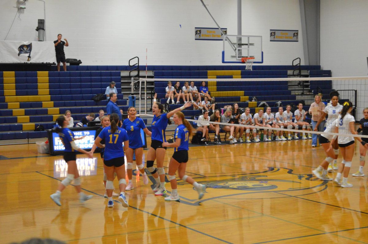 Bump, set, spike… The Lady Pirates celebrate their rally winning play placing them ahead. The players positioned themselves on offense and junior libero Addy Busby served. (Riley Wootten)