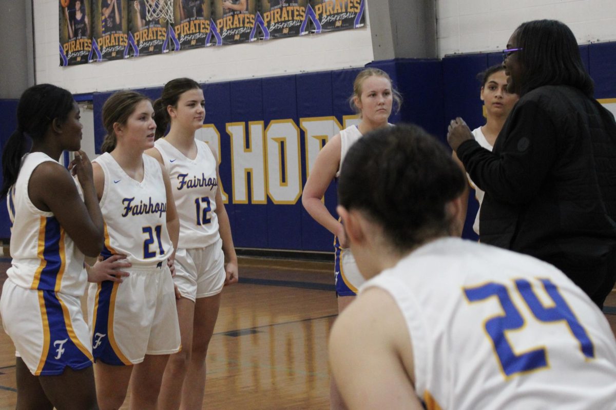 Pirates on three…Cassandra Agee, junior varsity coach, offers words of encouragement to her girls as they prepare for the game. Agee called two more timeouts during the remainder of the game. (Audrey Parsons)